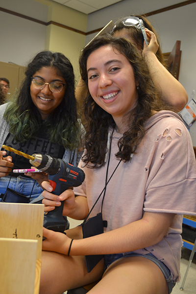 A GBAM GAMES camper uses a drill while working on her team's capstone project for the week: a 3D printer.